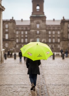 Copenhagen Free Walking Tour guide carrying an umbrella in front of Christiansborg Palace