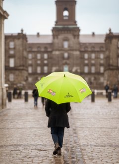 Copenhagen Free Walking Tour guide carrying an umbrella in front of Christiansborg Palace